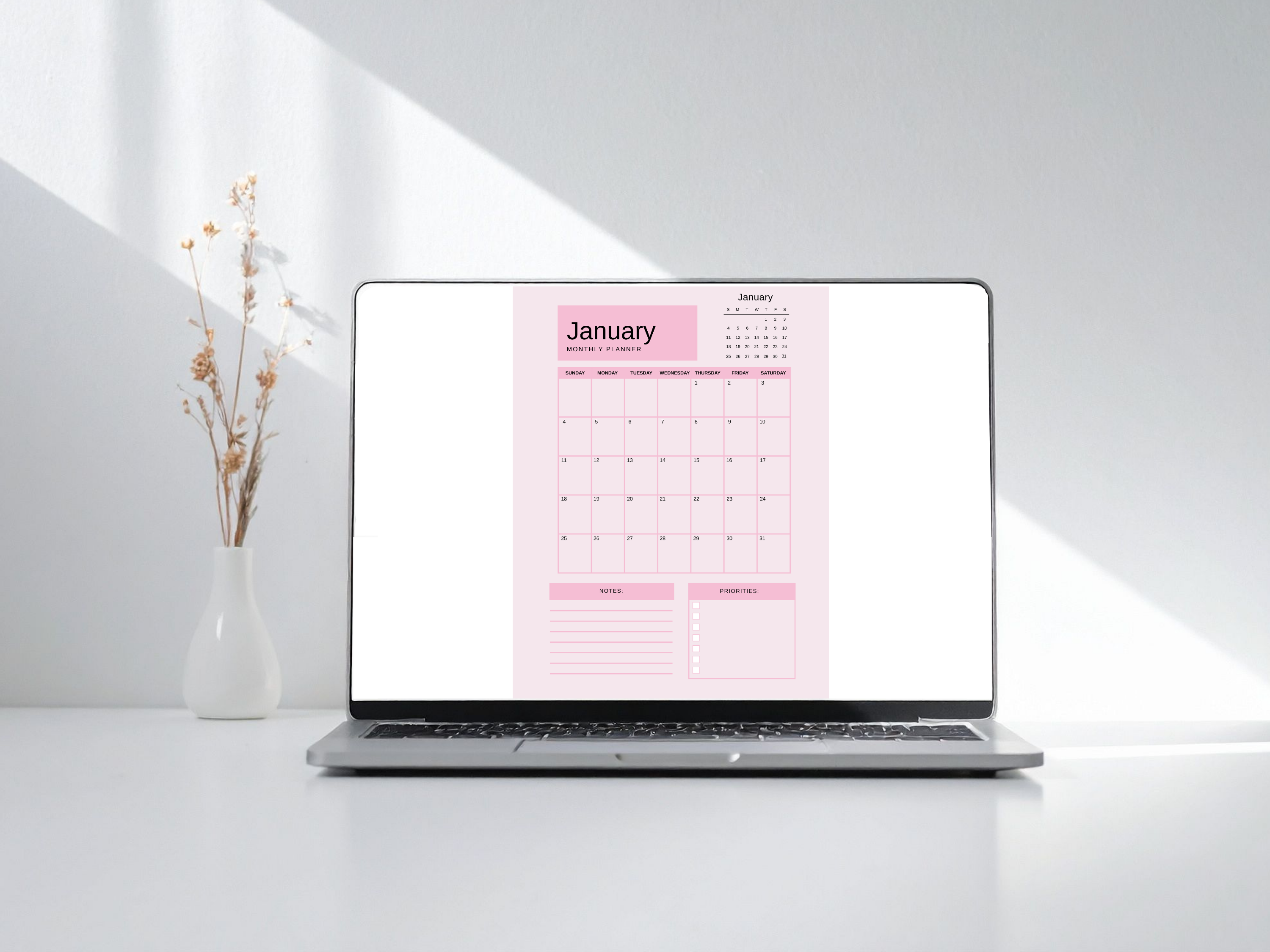 Laptop displaying a pink calendar on a white background
