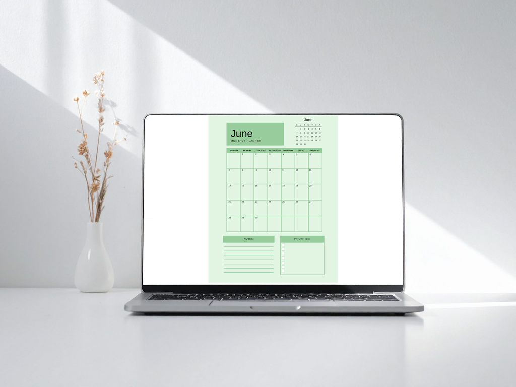 Laptop displaying a green calendar on a white background