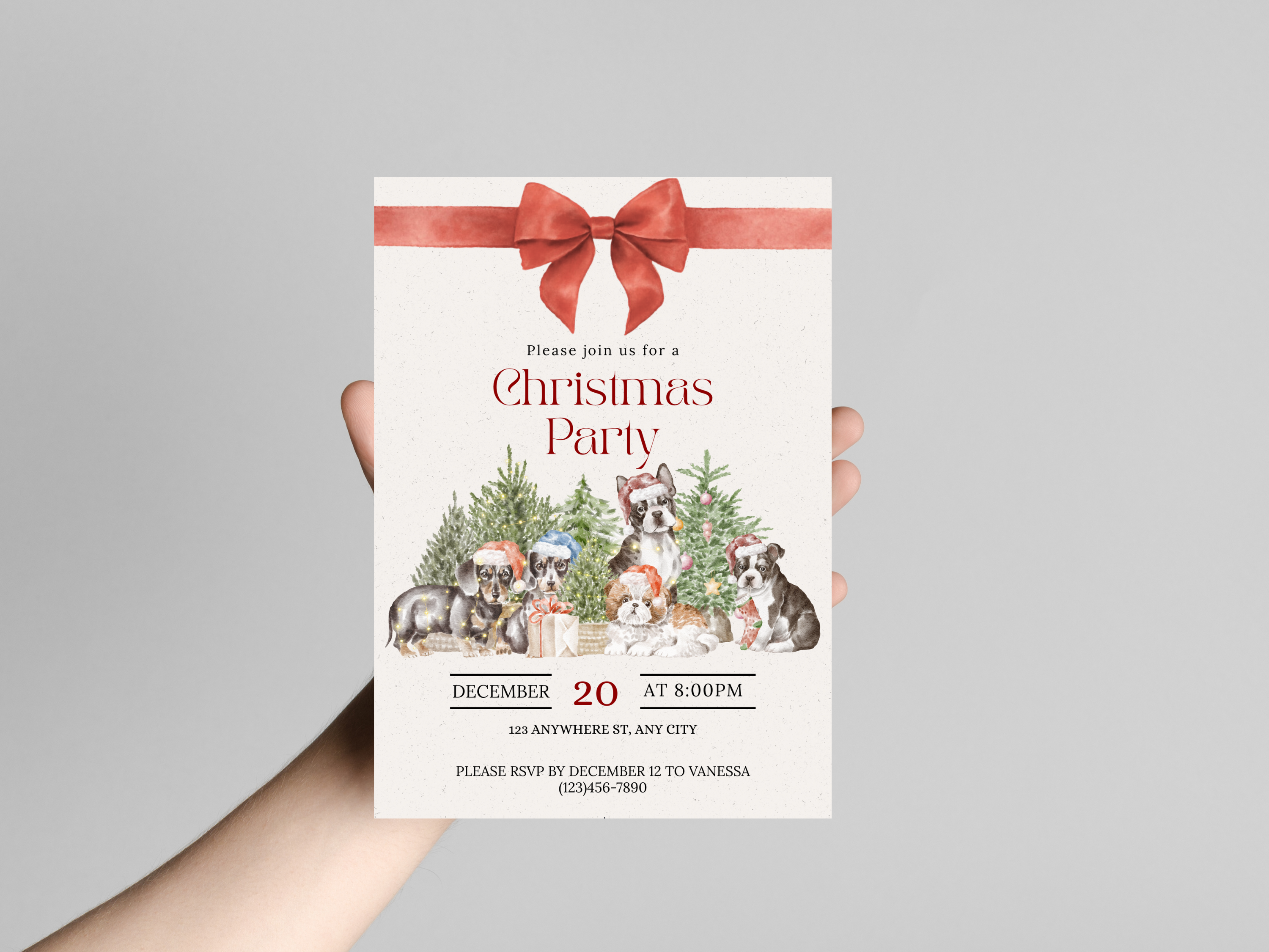 Hand holding a Christmas party invitation with festive design and red bow.