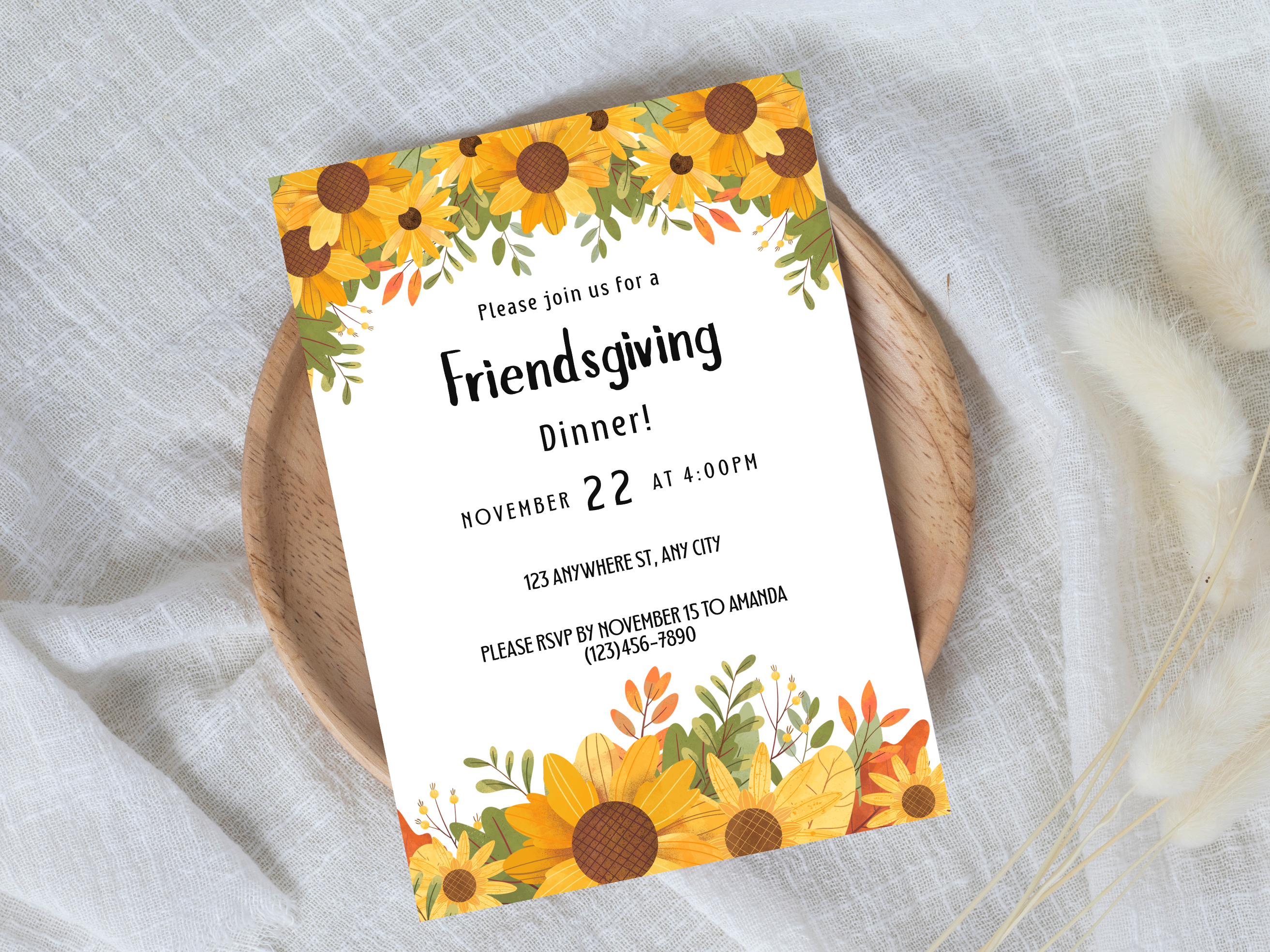 Invitation card for a Friendsgiving dinner with sunflower design on a white fabric background
