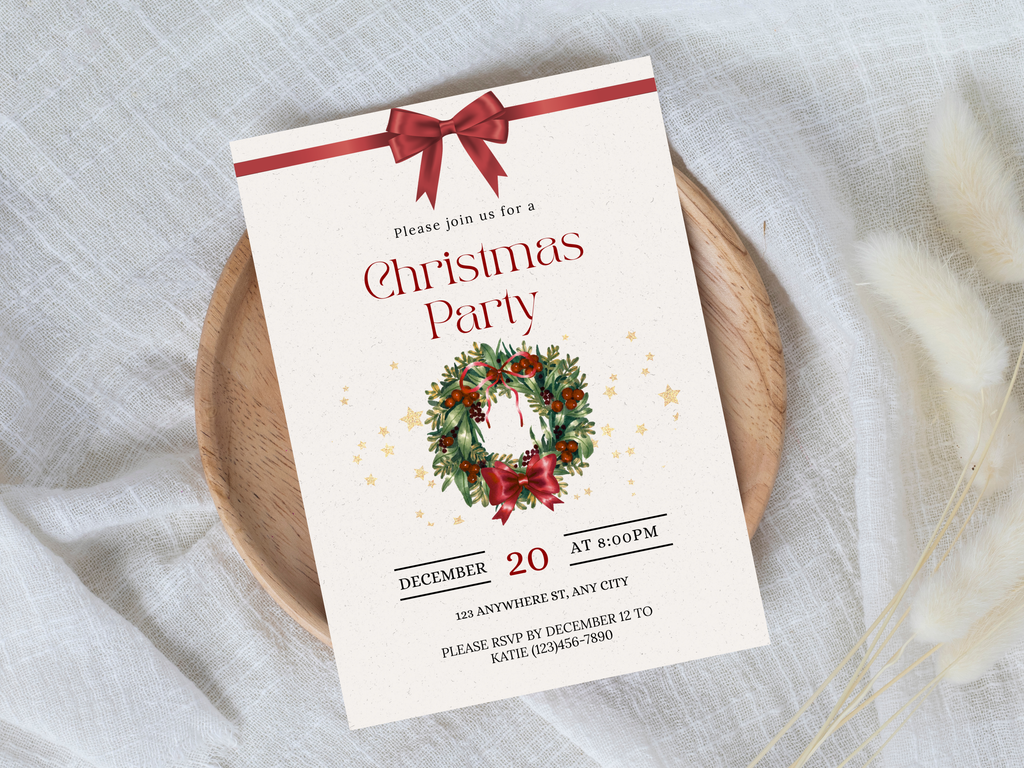 Christmas party invitation card with wreath and bow on a wooden plate