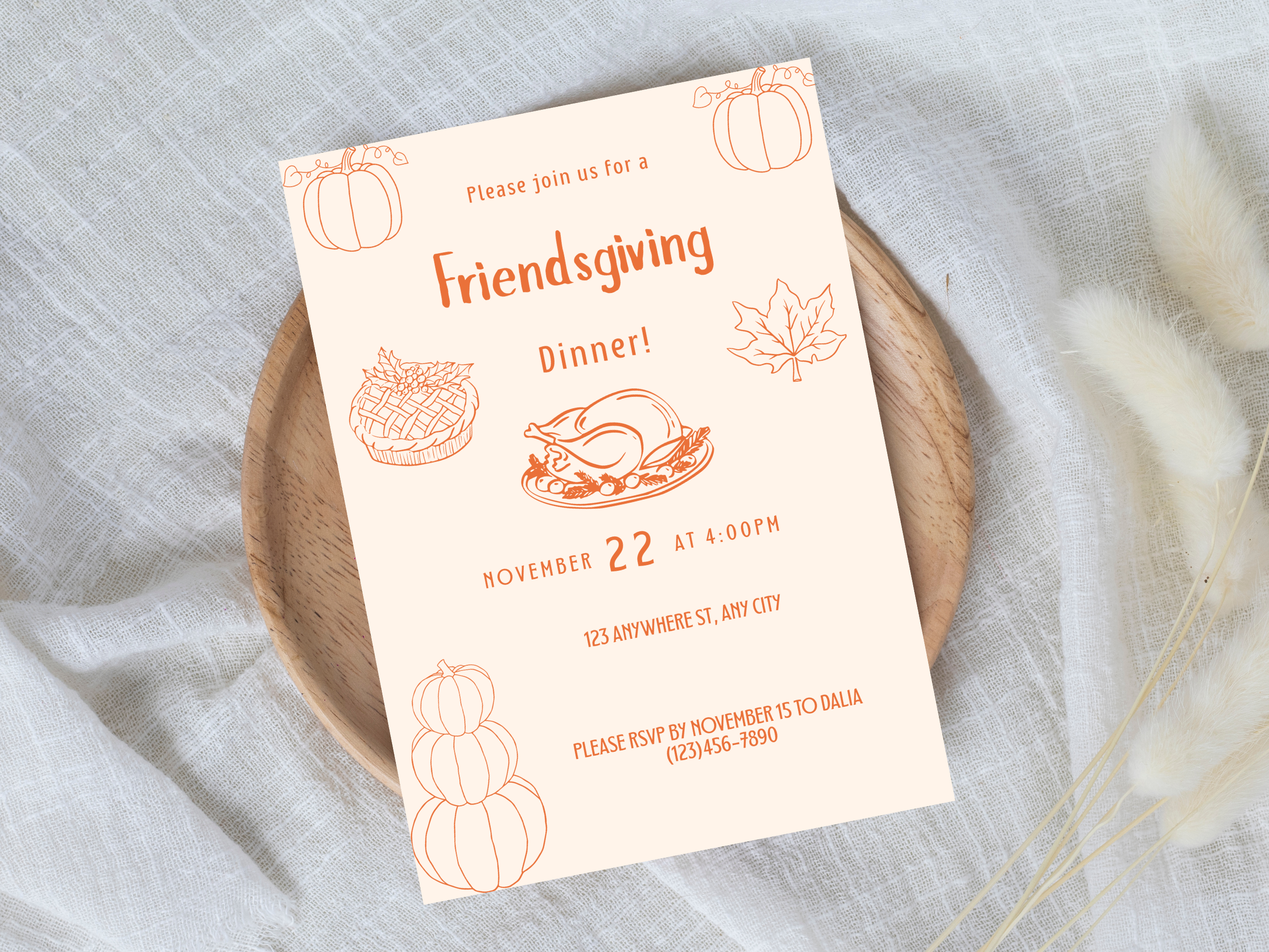 Friendsgiving dinner invitation card on a wooden plate with a light gray background