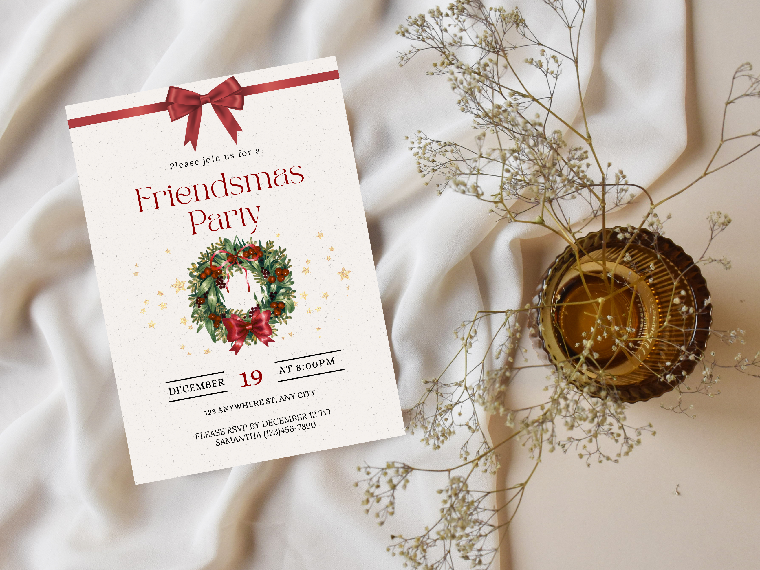 Friendsmas Party invitation with a wreath design on a white fabric background