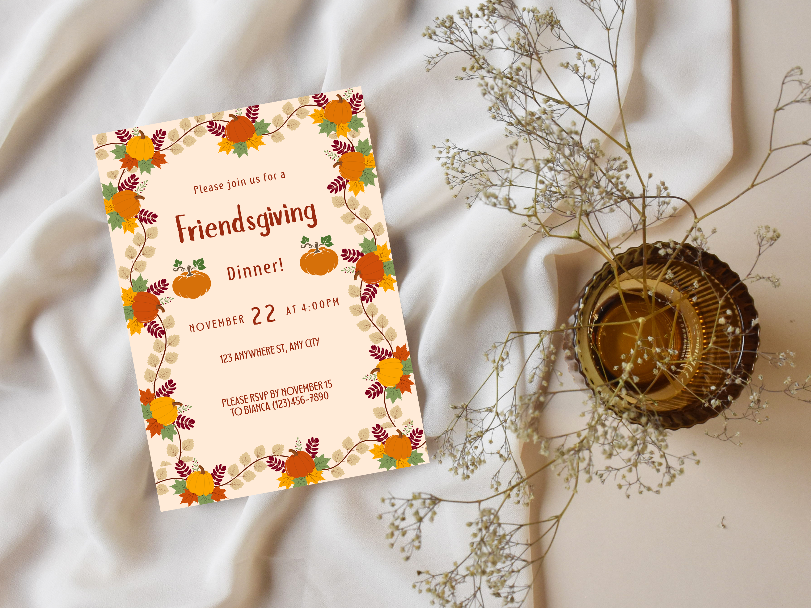 Friendsgiving dinner invitation card with autumnal design on a soft fabric background