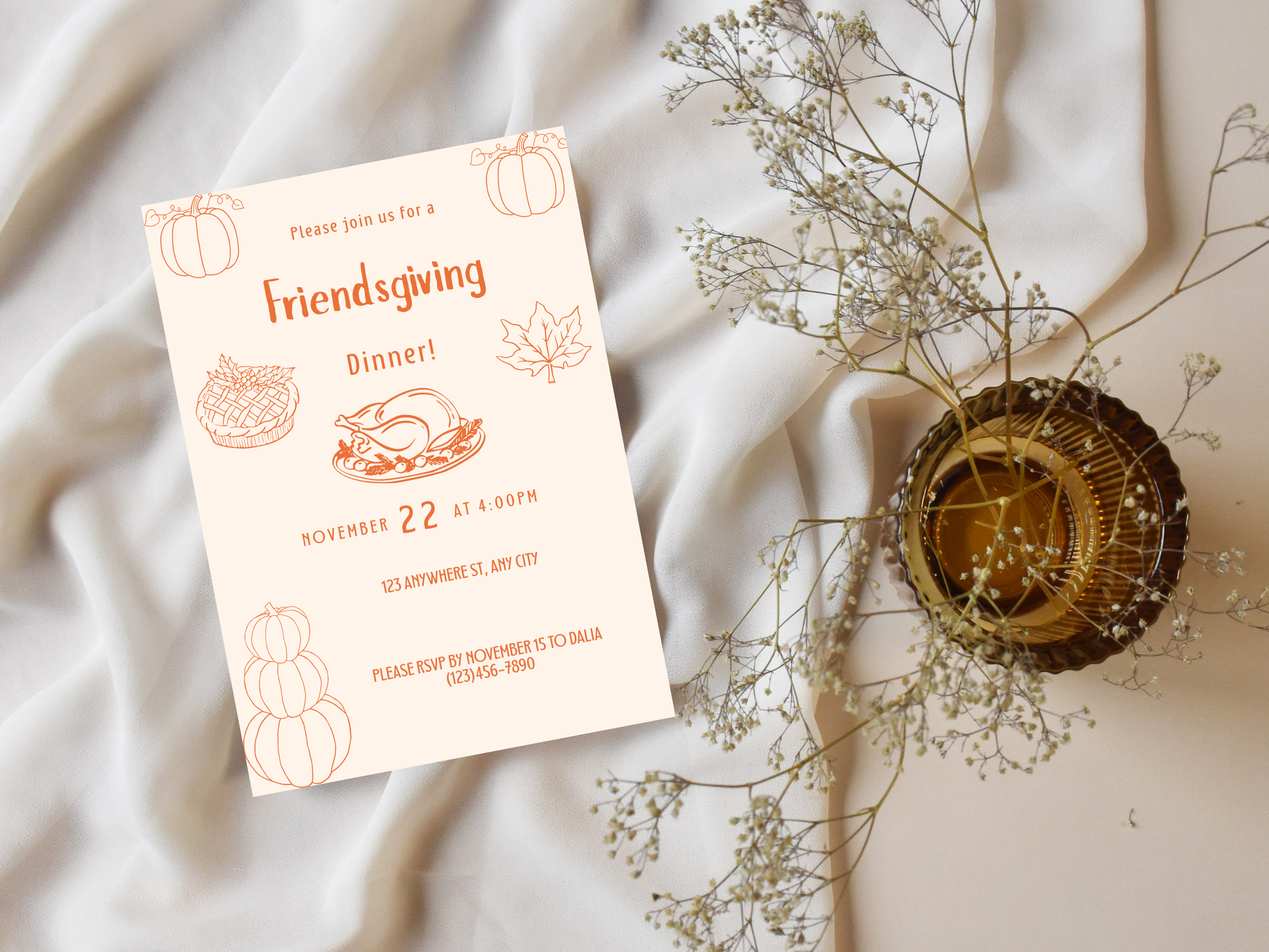 Friendsgiving dinner invitation card with decorative elements on a soft fabric background