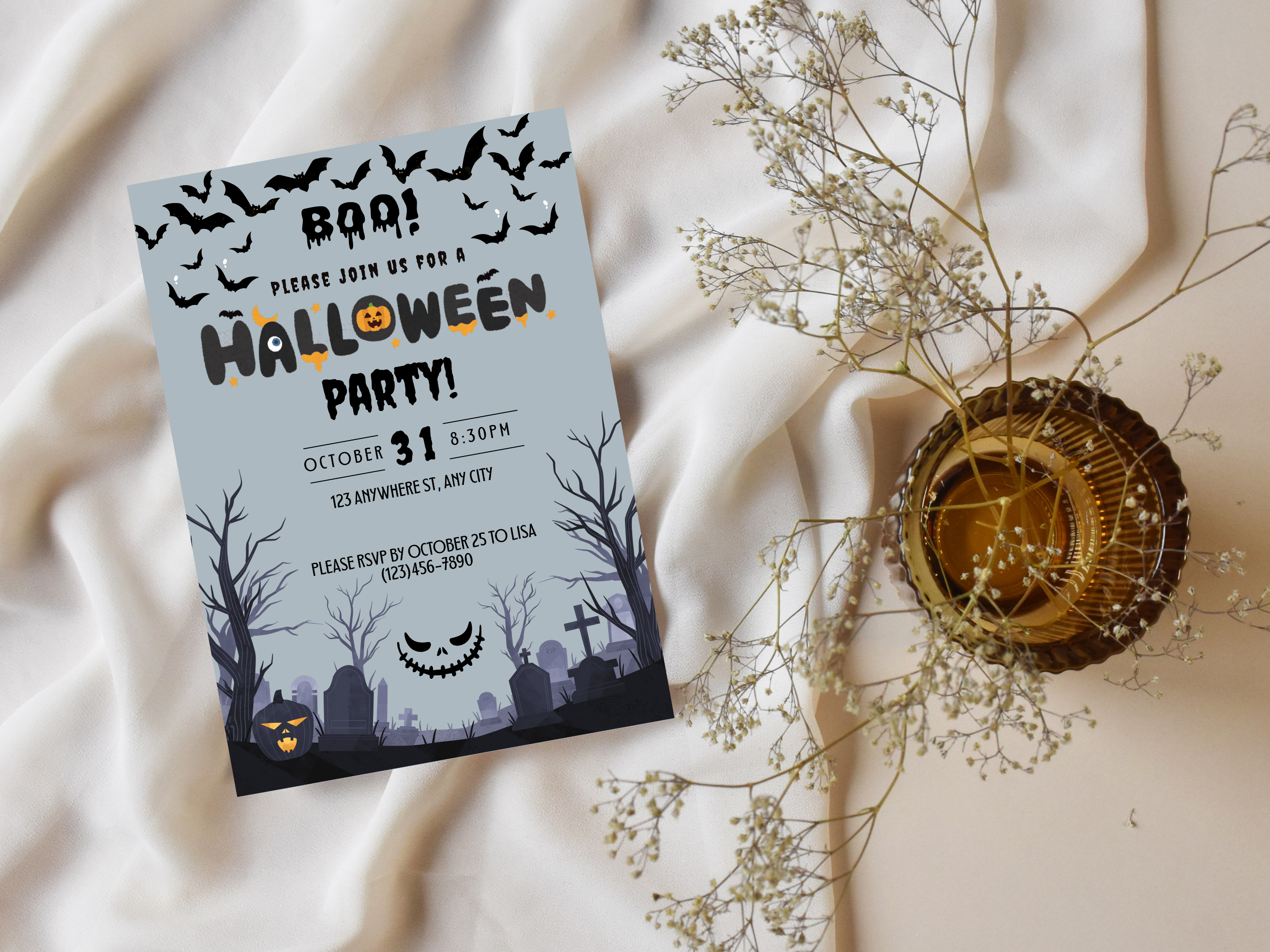 Halloween party invitation with graveyard design on a light fabric background