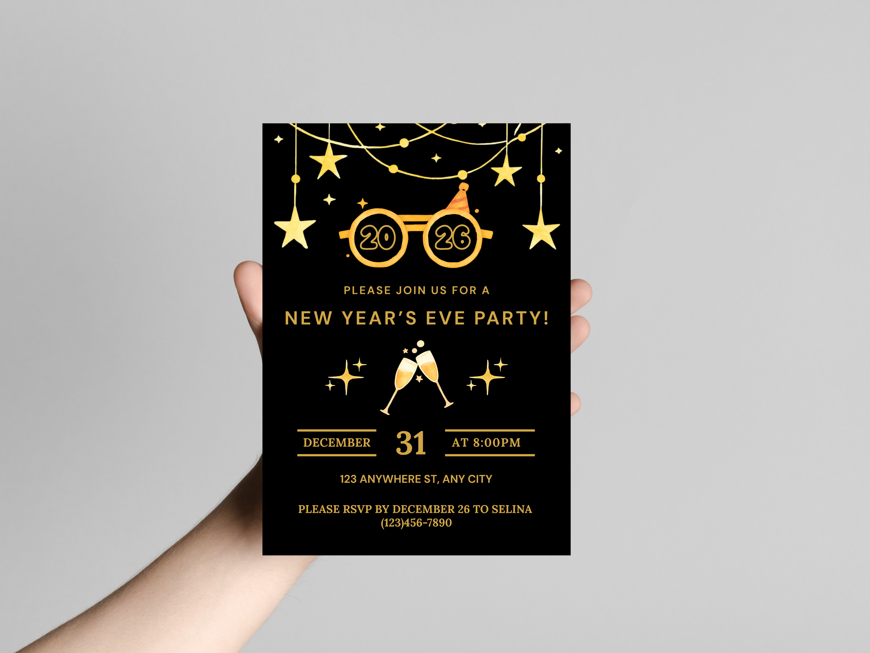 Hand holding a New Year's Eve party invitation card with gold text on a black background.