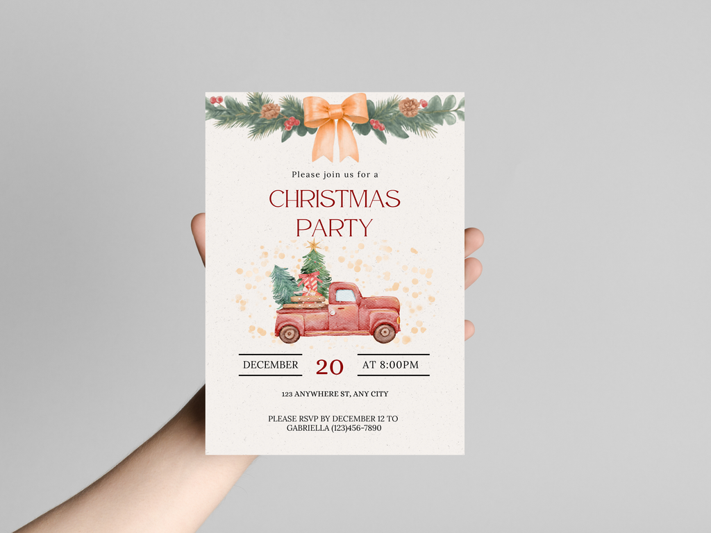 Hand holding a Christmas party invitation with a red truck and festive decorations.
